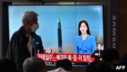 A man walks past a screen showing a news broadcast with file footage of a North Korean missile test, at a railway station in Seoul, South Korea, June 5, 2022.
