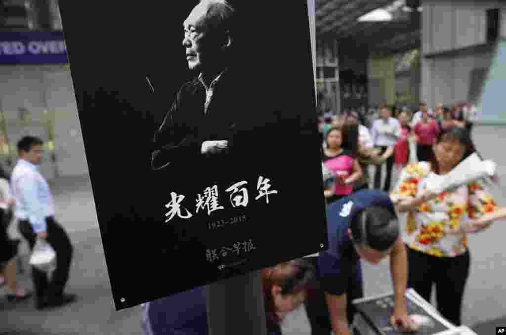 Pegawai kantoran di distrik keuangan Singapura membeli koran lokal edisi khusus mengenai kehidupan mendiang Lee Kuan Yew (23/3). (AP/Wong Maye-E)