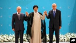 ប្រធានាធិបតី​រុស្ស៊ី លោក Vladimir Putin (ឆ្វេង) ប្រធានាធិបតី​អ៊ីរ៉ង់ លោក Ebrahim Raisi (កណ្ដាល) និង​ប្រធានាធិបតី​តួកគី លោក Recep Tayyip Erdogan ឈរ​ថតរូប​ជុំគ្នា​មុន​ជំនួប​ពិភាក្សា​របស់​ពួកគេ​នៅ​វិមាន​ Saadabad ក្នុង​ទីក្រុង​តេហេរ៉ង់ ប្រទេស​អ៊ីរ៉ង់ ថ្ងៃទី ១៩ ខែកក្កដា ឆ្នាំ២០២២។