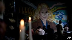 Varias velas arden cerca de un mural con la imagen de la fallecida ex primera dama de Argentina, María Eva Duarte de Perón, más conocida como "Evita", en el restaurante "El Santa Evita", en Buenos Aires, Argentina, el 24 de junio. Julio de 2022.
