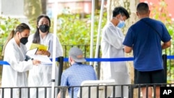 Trabajadores de la salud ayudan a las personas a insscribirse para recibir la vacuna contra la viruela del mono en la ciudad de Nueva York el 26 de julio de 2022. Foto AP.