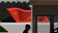 Seorang tentara berjaga di dekat pahatan bendera Partai Komunis China di Museum Partai Komunis China, 26 Mei 2022. China menggelar latihan militer di lepas pantai wilayahnya pada 30 Juli. (Foto: Ng Han Guan/AP)