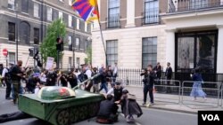 示威者把紙紮坦克擺在中國駐英大使館外，並且把紙紮坦克的砲口指向大使館。（美國之音鄭樂捷）