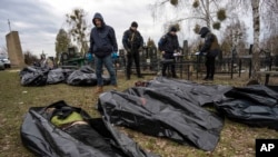 Policías con ayuda de voluntarios civiles recogen los cuerpos de ucranianos asesinados en Bucha por lo que Ucrania y las naciones occidentales acusan a Rusia de crímenes de guerra en esa ciudad periférica en la región de Kiev. (Foto Archivo / AP)