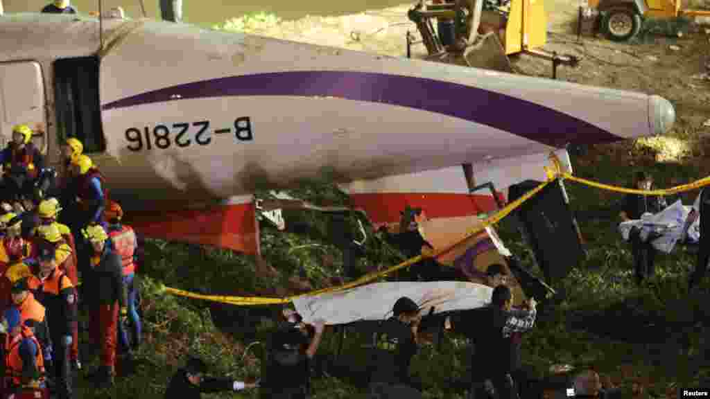 Une équipe de sauveteurs des restes de corps de passagers rivière après qu'un avion de TransAsia s'est abimé dans une rivière dans la nouvelle ville de Taipei.