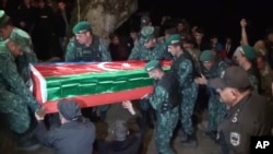 在冲突中被打死的一位阿塞拜疆军人的葬礼上，士兵们抬着他的棺木（2022年9月13号）。
