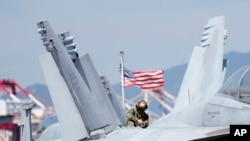 Un soldado estadounidense revisa el avión de combate F/A-18 Super Hornet en la cubierta del portaaviones de propulsión nuclear USS Ronald Reagan en Busan, Corea del Sur, el 23 de septiembre de 2022.