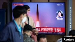 25일 한국 서울역 이용객들이 북한 단거리 탄도미사일 발사 TV 뉴스를 시청하고 있다. 