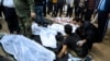 FILE - A man is comforted as he sits next to the body of a loved one who was killed in terrorist bombings in Kerman, Iran, on Jan. 3, 2024. A U.S. official says the United States government warned Tehran that an attack was planned.