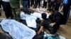 A man is being comforted by an another man as he sits next to the body of his loved who was killed in the explosions in the city of Kerman, about 820 kms southeast of the capital Tehran, Iran, Jan. 3, 2024. 