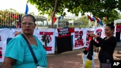 Un vendedor muestra camisetas que promocionan al presidente nicaragüense Daniel Ortega y al partido político gobernante del Frente Sandinista de Liberación Nacional.