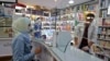 People wearing protective masks shop at a pharmacy in the Iranian capital Tehran, Feb. 24, 2020. 
