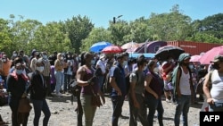 Hondureños y nicaragüenses hacen cola para ser vacunados con las vacunas Pfizer-BioNTech y Moderna.
