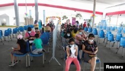 Los niños esperan que se les administre la vacuna de Pfizer contra la enfermedad del coronavirus en un complejo deportivo, en Lima, Perú, el 24 de enero de 2022.