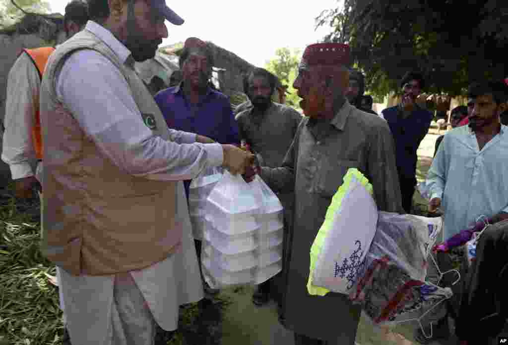 Victims of the unprecedented flooding from monsoon rains receive relief aid, organized by the Islamic group Jamaat-e-Islami Pakistan, in Sukkur, Pakistan, Sept. 4, 2022.