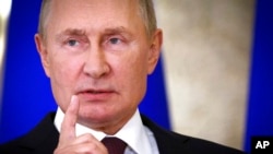 Presiden Rusia Vladimir Putin memberi isyarat kepada media setelah KTT Organisasi Kerjasama Shanghai (SCO) di Samarkand, Uzbekistan, Jumat, 16 September 2022. (Foto: via AP)