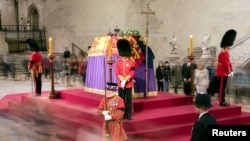 Una fotografía de larga exposición que muestra a miembros del público mientras desfilan frente al ataúd de la Reina Isabel II, envuelto en el Estandarte Real con la Corona del Estado Imperial y el orbe y el cetro del Soberano, yaciendo en el catafalco en Westminster Hall, en el Palacio. de Westminster, Londres, antes de su funeral el lunes. Fecha del cuadro: jueves 15 de septiembre de 2022. Danny Lawson/Pool vía REUTERS