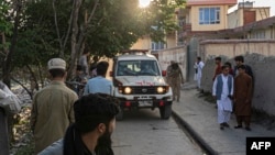 Para pejalan kaki memperhatikan ambulans yang membawa korban dekat lokasi ledakan bom di Kabul, Jumat, 29 April 2022. (Foto: Wakil Kohsar / AFP)