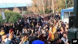 In this Saturday, Dec. 30, 2017 file photo taken by an individual not employed by the Associated Press and obtained by the AP outside Iran, university students attend a protest inside Tehran University while anti-riot Iranian police prevent them to join o