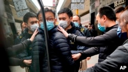 资料照片：警方在搜查香港《立场新闻》办公室后带走该媒体的编辑林绍桐。(2022年1月4日)