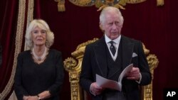 英国新国王查尔斯三世，坐在他身后右边的是卡米拉王后。（美联社照片）