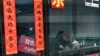 A woman with her dog plays a scratch-off lottery ticket in a lottery store at a shopping mall in Beijing, Feb. 6, 2025.