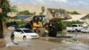 Bomberos de la comunidad de Cathedral City, California, rescatan a residentes en la pala de una topadora en medio de un lodazal dejado por el paso de la tormenta tropical Hilary el 21 de agosto de 2023.