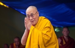 FILE - Tibetan spiritual leader the Dalai Lama greets devotees as he arrives to give a religious talk at the Tibetan Children's Village School in Dharmsala, India.