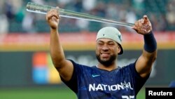 El pelotero venezolano Elías Díaz, de la Liga Nacional, levanta su trofeo al Jugador Más Valioso del Juego de las Estrellas de las Grandes Ligas, celebrado en el T-Mobile Park de Seattle, este martes 11 de Julio de 2023.