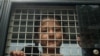 FILE - An ethnic Uighur boy inside a police van in Khlong Hoi Khong, Thailand is seen in this March 15, 2014 photo.