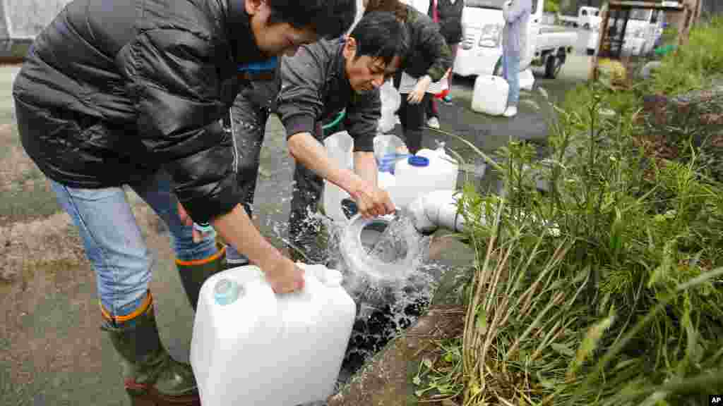 Des habitants récupèrent de l'eau de source dans des bouteilles en plastique à Aso, préfecture de Kumamoto, Japon, 17 avril 2016. 