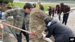 Varias personas llenan sacos de arena en San Francisco, California, como preparación a intensas lluvias pronosticadas para la semana, el 3 de enero de 2023.