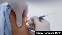 资料照片：德国东部一所大学医院正在给人注射默德纳公司生产的疫苗（2021年1月22日）