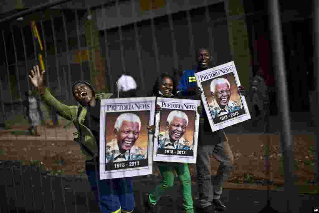 Sul-africanos exibem poster do ex Presidente Nelson Mandela e cantam durante o cortejo fúnebre em Pretoria. Dez. 11, 2013.