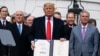 Президент США Дональд Трамп демонстрирует только что подписанное им соглашение о торговле с Канадой и Мексикой. 29 января 2020 года
