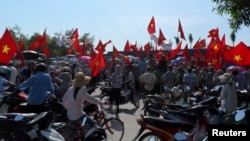 កម្មករ​គ្រវី​ទង់ជាតិ​វៀតណាម​ក្នុង​អំឡុង​បាតុកម្ម​ប្រឆាំង​ចិន​នៅ​ឯ​រោងចក្រ​ស្បែក​ជើង​គ្រប់គ្រង​ដោយ​ជន​ជាតិ​ចិន​មួយ​កន្លែង​​ខេត្ត ​Thai Binh ភាគ​ខាង​ជើង​ប្រទេស​វៀតណាម កាល​ពី​ថ្ងៃ​ទី​១៤ ខែ​ឧសភា ឆ្នាំ​២០១៤។