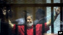 Mantan Presiden Mohammed Morsi berada dalam kurungan saat menghadiri sidang di Akademi Kepolisian Nasional di Kairo, Mesir (Foto: dok). Pengadilan Mesir telah membatalkan hukuman mati terhadap Morsi. 