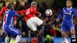 Paul Pogba de Manchester United tente une aile de pigeon au milieu de N'Golo Kante, à gauche, et Willian, à droite, de Chelsea au cours d’un match du championnat anglais, entre Chelsea et Manchester United au stade à Londres, le 13 mars 2017.