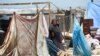 Una mujer palestina desplazada junto a sus pertenencias mientras la gente evacua el área de Mawassi en las afueras del suroeste de Khan Yunis en el sur de la Franja de Gaza el 28 de junio de 2024, en medio del conflicto en curso entre Israel y el grupo militante Hamas.