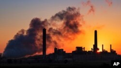 FILE - The Dave Johnson coal-fired power plant is silhouetted against the morning sun in Glenrock, Wyo., July 27, 2018.