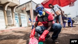 Petugas medis mengenakan alat pelindung saat mencampur air dan klorin di Goma, Republik Demokratik Kongo (DRC), 31 Juli 2019.