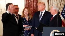 El secretario de Estado, Mike Pompeo es juramentado por el vicepresidente de EE.UU., Mike Pence (derecha) en presencia del presidente Donald Trump y de Susan Pompeo, esposa del nuevo jefe de la diplomacia estadounidense. Washington, 2 de mayo, de 2018.
