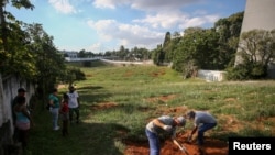 Sepultureros entierran a una víctima de COVID-19 en un cementerio de la ciudad de Porto Alegre, Brasil, el 6 de abril de 2021.