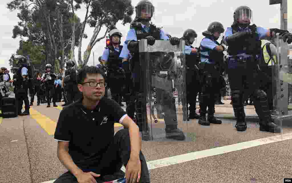 沙田反送中大遊行結束後,有示威者在源禾路警民衝突後,坐在防暴警察防線前。(美國之音湯惠芸拍攝)
