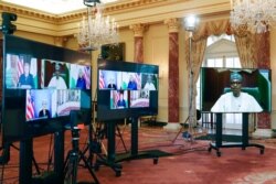 Nigeria's President Muhammadu Buhari appears on a screen, at right, as he speaks during a virtual bilateral meeting with Secretary of State Antony Blinken at the State Department in Washington, April 27, 2021.