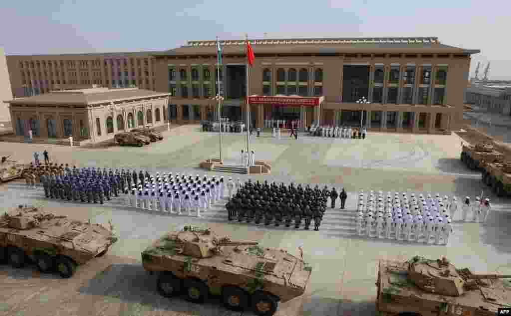 中国人民解放军人员参加吉布提中国军事基地开幕式。 这是中国第一个海外海军基地,是中国扩大其国外军事存在的重要一步(2017年8月1日)。地缘情报分析公司斯特拉福(Strarfor)的在线刊物“斯特拉福世界观”(Stratfor Worldview)和卫星图像分析公司“全资源分析”(Allsource Analysis)提供的两张图像显示,中国在吉布提的基地有三层安全防御,戒备森严。斯特拉福公司分析,这处基地有大约23000平方米的地下空间。该基地距离美军在吉布提的驻军总部只有八英里远,美国在吉布提的驻军有4500人。此外,日本、法国、英国等国在吉布提也有驻军。