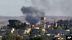 Asap tampak mengepul akibat serangan artileri di kota Kobani, Suriah (1/10).
