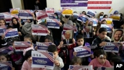 FILE - Afghan refugees hold placards during their meeting to discuss situation after President Donald Trump paused the U.S. refugee programs, in Islamabad, Pakistan, Jan. 24, 2025.