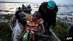 Des congolais embraquent dans des pirogues sur la rive du lac Albert à Tchomia, Ituri, RDC, 5 mars 2018.