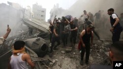 Palestinos sacan un cadáver de los escombros de un edificio después de un ataque aéreo israelí al campo de refugiados de Jebaliya, Franja de Gaza, el lunes 9 de octubre de 2023.